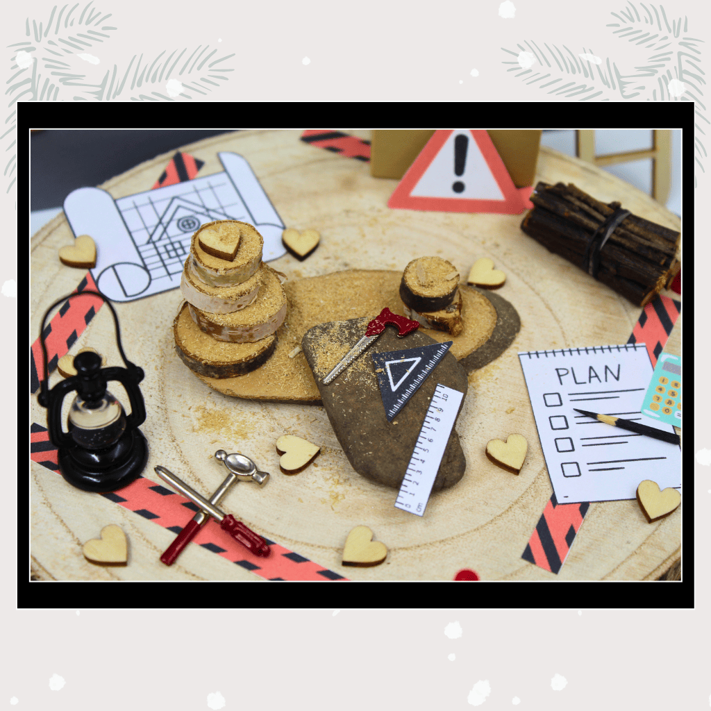 Detailreiche Nahaufnahme der Wichtel-Baustelle mit Miniaturwerkzeug, Bauzeichnungen, Holzscheiben und Herzdekoration – perfekt für kreative Adventswichtel-Deko.