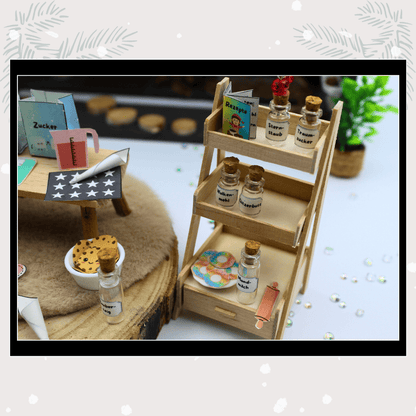 Regal voller Wichtelzubehör im Puppenhaus-Look: kleine Fläschchen mit Sternenstaub, Wolkenmehl und Zucker, dazu Rezepte und Wichtel Briefpapier. Dieses detailverliebte Wichtelset lässt Weihnachten lebendig werden und zaubert Magie hinter jeder Wichteltür – ideal für Adventskalender und Wichtel Sets.