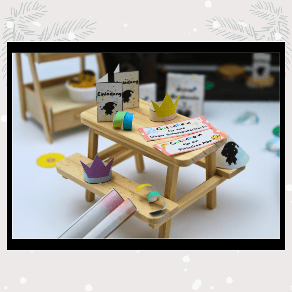 Kleine Wichtelgutscheine, Mini-Kronen und Wichtelbriefe auf einem Tisch im Puppenhaus, dekoriert für Weihnachten. Liebevolles Wichtel Briefpapier und Zubehör für Adventskalender, Wichtelset und magische Wichtelideen.