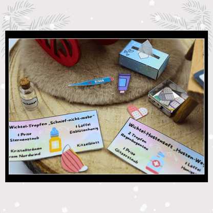 Auf einem Holztisch im Puppenhaus liegen Wichtel-Rezeptkarten für magische Tropfen und Hustensaft, dazu Thermometer, Pflaster und weitere Wichtelaccessoires. Die Szene erinnert an die Magie von Weihnachten, wenn der Weihnachtswichtel kleine Überraschungen hinter der Wichteltür vorbereitet, ideal als Idee für Adventskalender und Wichtel Sets.